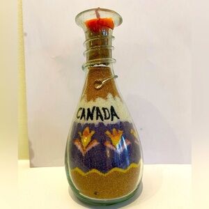 Sand Art in a bottle with a small candle wick on the top